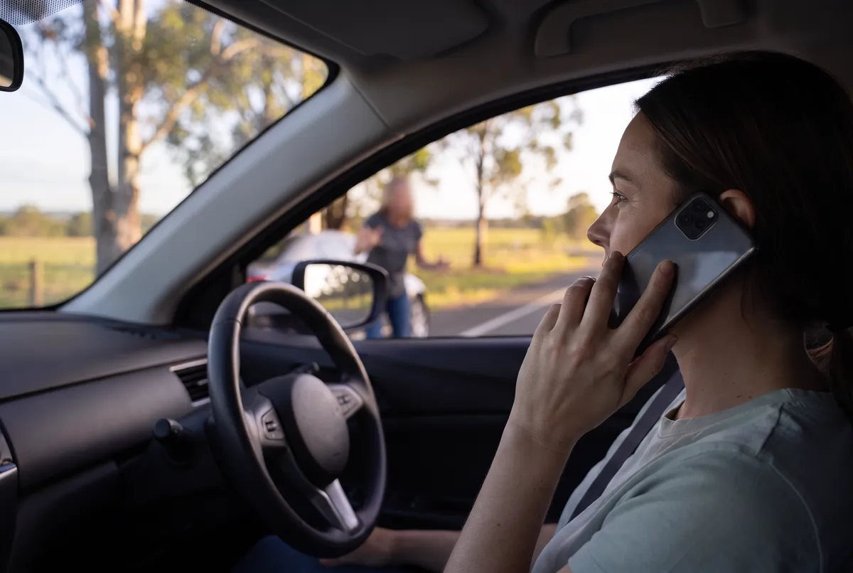 A driver remaining safely inside a locked car during a tense roadside confrontation while calling for help