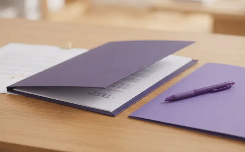 An estate planning folder with an original document and a separate certified-copy folder beside a purple pen.